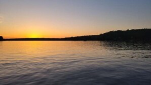 A sunset over a calm body of water with a silhouette of a landmass on the right. - Lake Getaway at Coventry Lake! close to Uconn (Coventry)