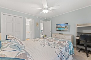 A bedroom with a bed, a desk, a chair, and a ceiling fan. - Beachmaster 104-2BR Oceanfront Condo (North Myrtle Beach)