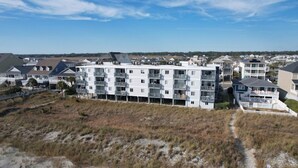 A multi-story residential building with balconies, located near a beach. - Beachmaster 104-2BR Oceanfront Condo (North Myrtle Beach)