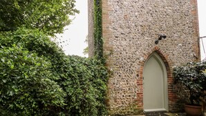 A stone building with a white door and a small arched window. - Hapton Folly (Waterlooville)
