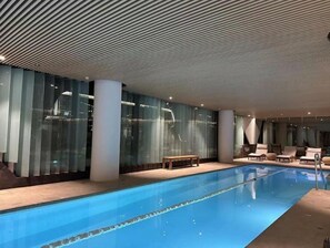 Relax and unwind in our indoor pool area, featuring a sleek design and comfortable lounge seating.