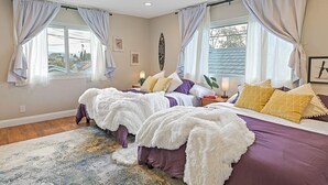 Une chambre avec deux lits, une grande fenêtre et une vue sur l’extérieur.