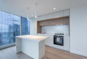 Enjoy cooking in this well-equipped kitchen with a large island, cabinetry, and a sleek countertop.