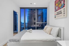 Enjoy a city view from the comfort of this stylish room, featuring a large bed and ample natural light.