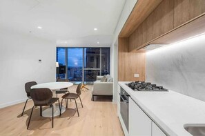 Enjoy a stylish dining experience in this modern kitchen and dining area with a stove and round table for four.