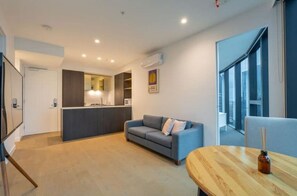 Relax in this stylish living area with a sofa, coffee table, and kitchenette.