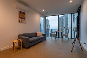 Relax in this stylish living space with a city view, featuring a sofa, stool, and photography stand.