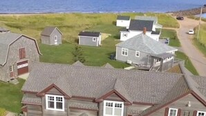 Vue aérienne d’un quartier résidentiel avec des maisons, une route et une plage.