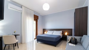 A modern hotel room with a bed, a sofa, a desk, and a chair. - B&B Torre Talao (Scalea)