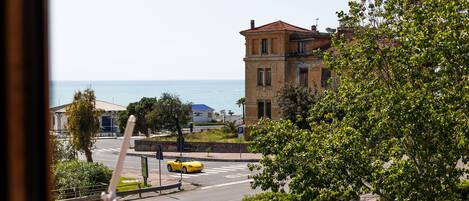 Une vue sur la côte, avec un bâtiment, une voiture jaune et un ciel dégagé.