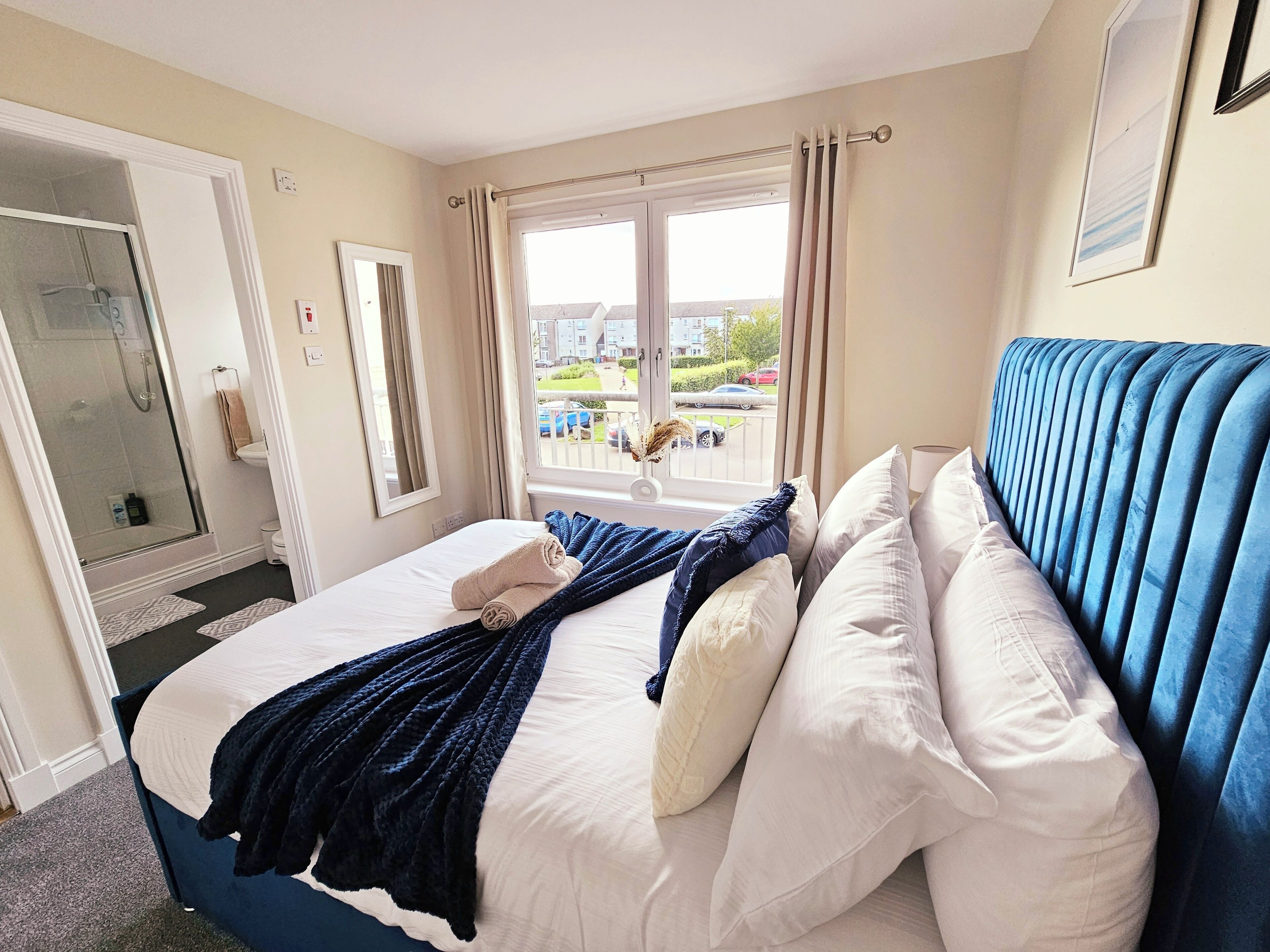 Ein Hotelzimmer mit Bett, einem Vorhangfenster, einer Dusche und Blick nach außen.