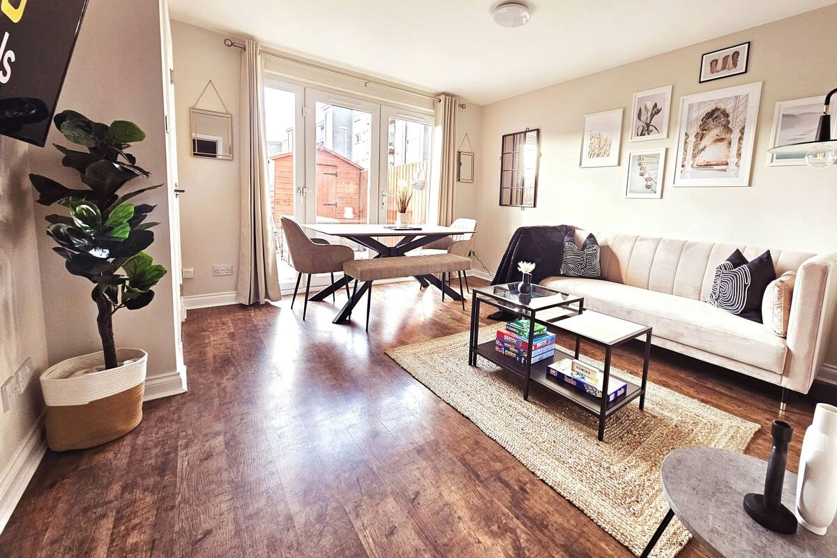 A modern living room with a sofa, coffee table, and dining area.