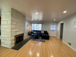 Relax in this inviting living room with a stone fireplace, comfortable sofa, and large window.