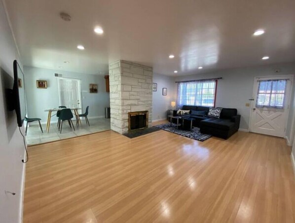 Relax by the stone fireplace in this stylish living area with a sofa and dining space.