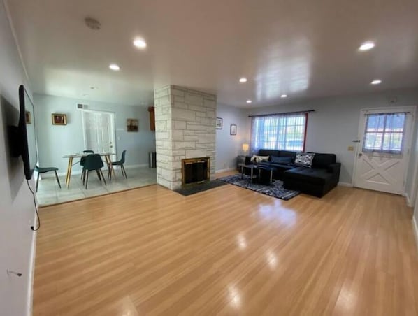 Relax by the stone fireplace in this stylish living area with a sofa and dining space.