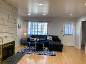 Relax in this stylish living room with a sofa, ottoman, and fireplace.