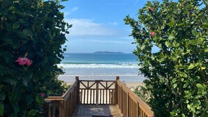 A wooden boardwalk leading to a beach with clear skies and ocean views. - Residencial Guilhermina (Bombinhas)