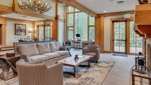A spacious living area with a large sofa, patterned chairs, a coffee table, and a chandelier. - Ski-In Breckenridge Condo w/ Fireplace + Balcony! (Breckenridge)