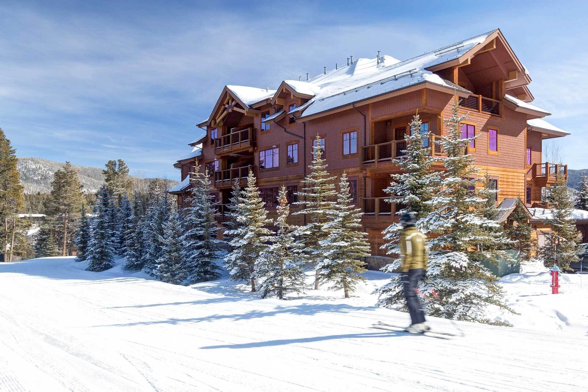 A multi-story wooden lodge with balconies and large windows, surrounded by snow-covered trees. - Ski-In Breckenridge Condo w/ Fireplace + Balcony! (Breckenridge)