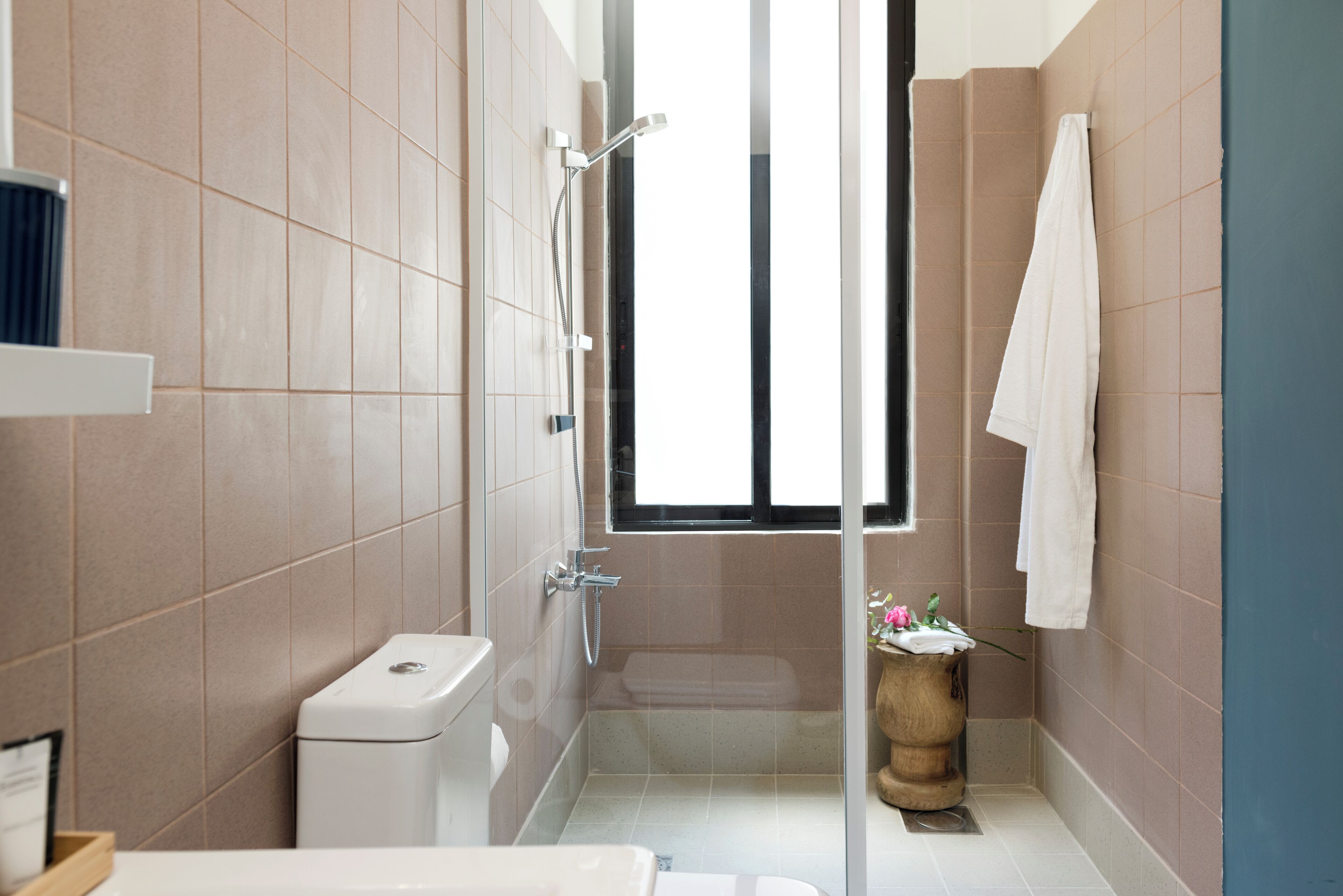 Ein modernes Badezimmer mit Toilette, Dusche und einem Fenster für natürliches Licht.