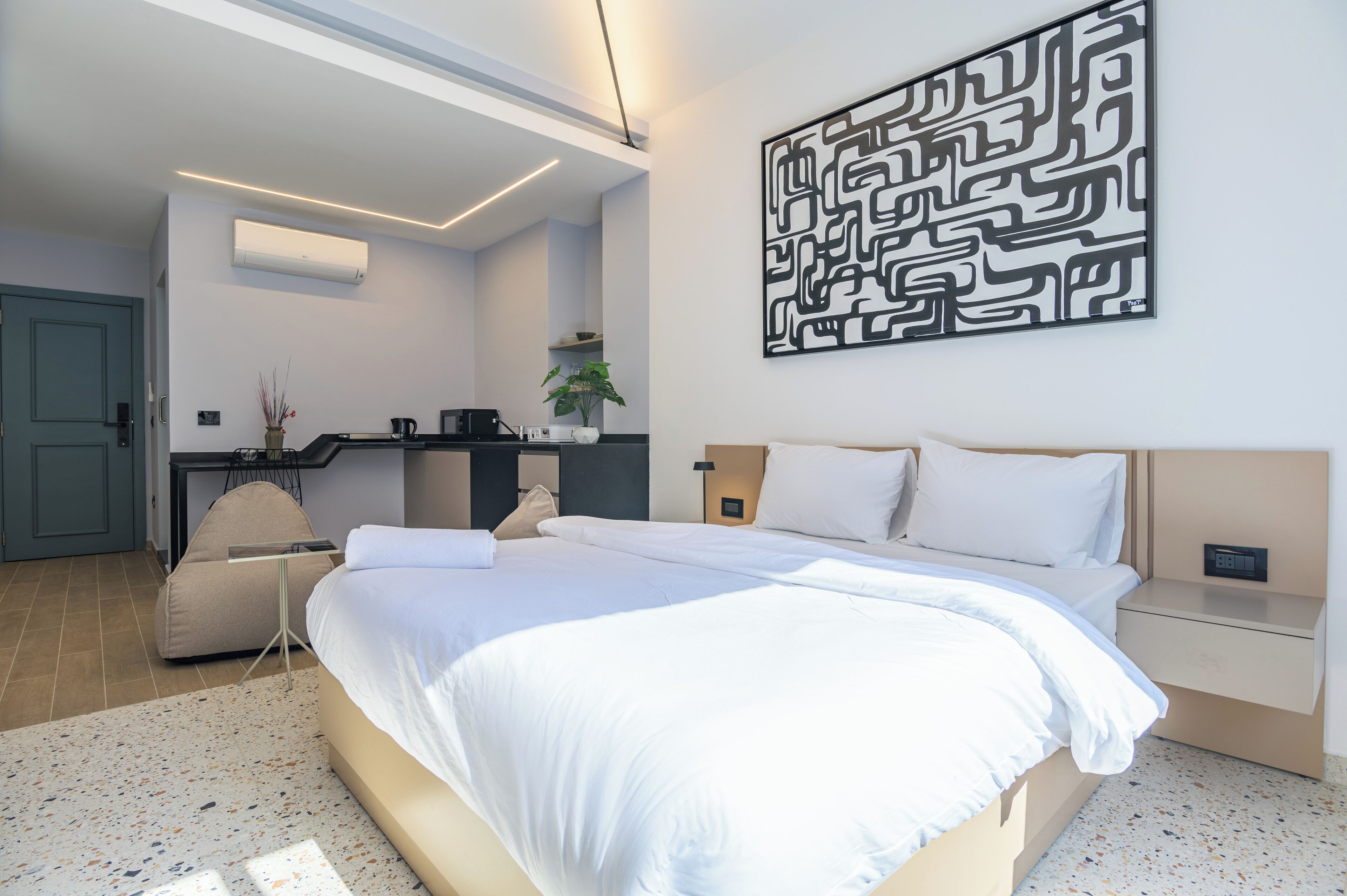 Ein modernes Schlafzimmer mit einem großen Bett, einem Schreibtisch und einem Wandbild.