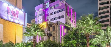 A multi-story building with balconies and a large billboard.
