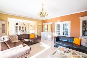 A living room with two sofas, a coffee table, and a chandelier. - Peaceful retreat w/ heatable pool & garden (Carvoeiro)