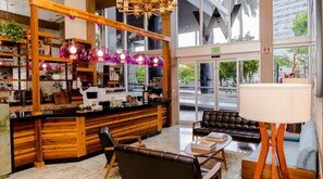 Relax in a stylish seating area with a leather sofa and round table, surrounded by pendant lights and a service counter.