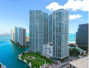 Situated by a body of water, this high-rise building offers stunning views and a grid-like pattern of windows.