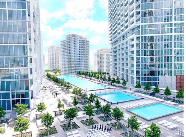 Residents can enjoy a central pool area surrounded by lush gardens and trees.