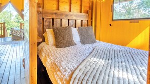 A wooden cabin bedroom with a bed, pillows, and a window overlooking greenery. - The Owls Hollow - UK45297 (Bishop Thornton, near Harrogate)