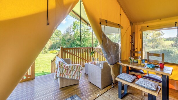 A cozy interior with a wooden deck, a hanging chair, and a table with various items. - The Owls Hollow - UK45297 (Bishop Thornton, near Harrogate)