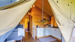 A cozy, tent-like interior with a kitchenette, wooden floors, and a small seating area. - The Owls Hollow - UK45297 (Bishop Thornton, near Harrogate)