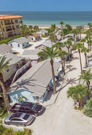 A coastal residential area with a beachfront view, including a multi-story building and several single-story homes with palm trees. - Beach Side, Resort Pool, Patio, Walk to Town!
 (Indian Rocks Beach)
