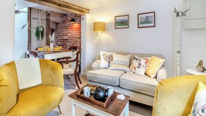 A living room with a sofa, two armchairs, a coffee table, and a dining area with a table and chairs.
