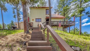 A wooden staircase leading to a house with a balcony, surrounded by trees. - Ruidoso Cabin w/ Deck + Views: 4 Mi to Winter Park (Ruidoso)