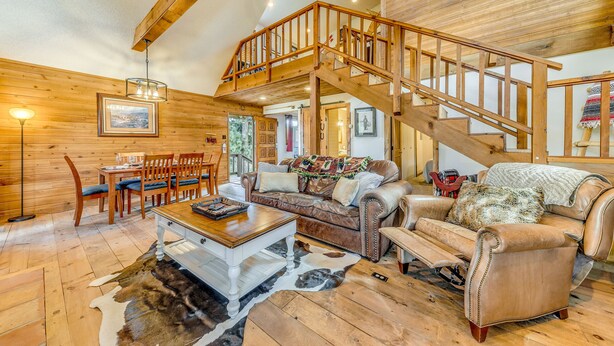 A spacious living room with a wooden staircase, a dining area, and a cozy seating arrangement. - Ruidoso Cabin w/ Deck + Views: 4 Mi to Winter Park (Ruidoso)