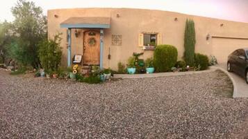 A building with a blue door, a small porch, and potted plants.