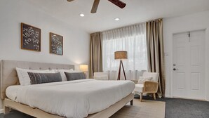 A spacious bedroom with a large bed, a bedside table, a floor lamp, and a chair. - MARINE VILLAS HOLLYWOOD  (Hollywood)
