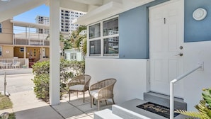 A residential building with a blue exterior, white door, and a small porch with two wicker chairs. - MARINE VILLAS HOLLYWOOD  (Hollywood)