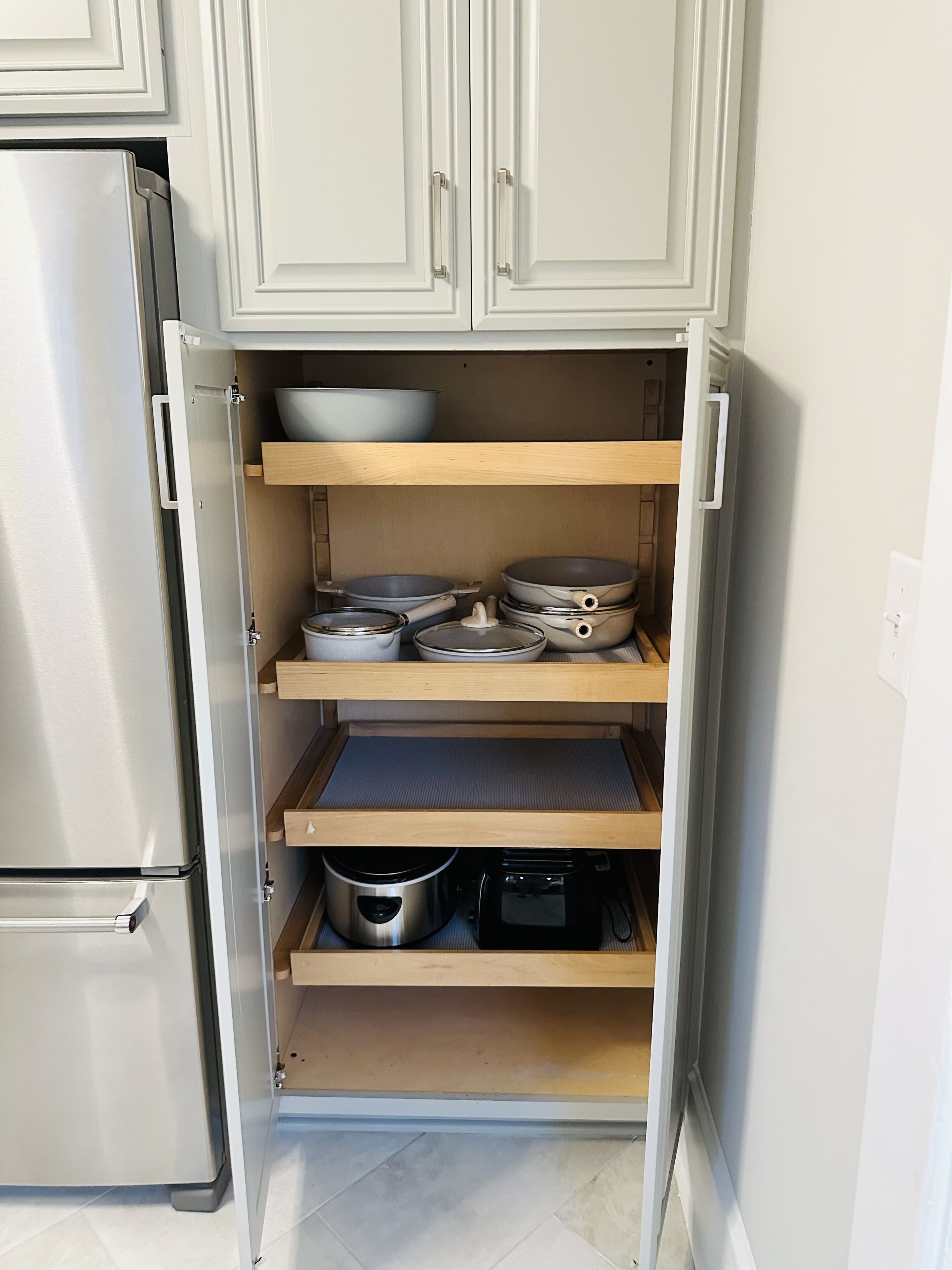 A compact kitchen with white cabinets, a built-in oven, and a microwave.