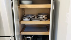 Una cocina compacta con armarios blancos, horno empotrado y microondas.