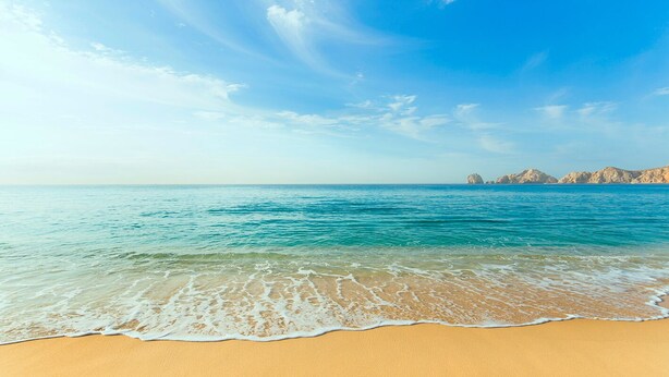 Una spiaggia con acque cristalline e una riva sabbiosa.