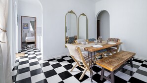 Un comedor con piso a cuadros, mobiliario de madera y paredes espejadas.