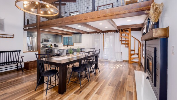 A spacious dining area with a wooden table and chairs, a staircase, and a kitchen in the background. - NEW! Family Cabin Retreat in Munds Park w/ Cozy Back Patio & Loft (Sedona)