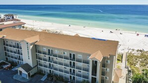 Un hotel de varios pisos con vista al mar, que cuenta con balcones y un estacionamiento.
