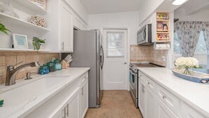 A modern kitchen with white cabinetry, stainless steel appliances, and a tiled backsplash. - Hot Tub-Dog & Kid Friendly-FREE digital guidebook! (Rockport)