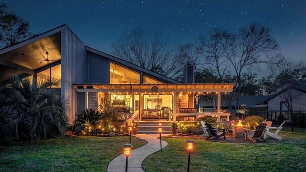 A modern house with a covered porch, outdoor seating, and a pathway leading to the entrance. - Karaoke,Arcade,Firepit,PrivateDock,Projector,Kayaks,SUP,Fishing,Massage,Mixology (Montgomery)