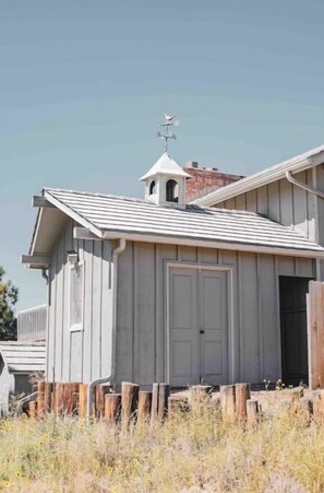 Situated in a rural setting, this charming building features a gabled roof and a small bell tower.