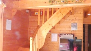 Un interno in legno con una scala, un angolo cottura e un televisore.